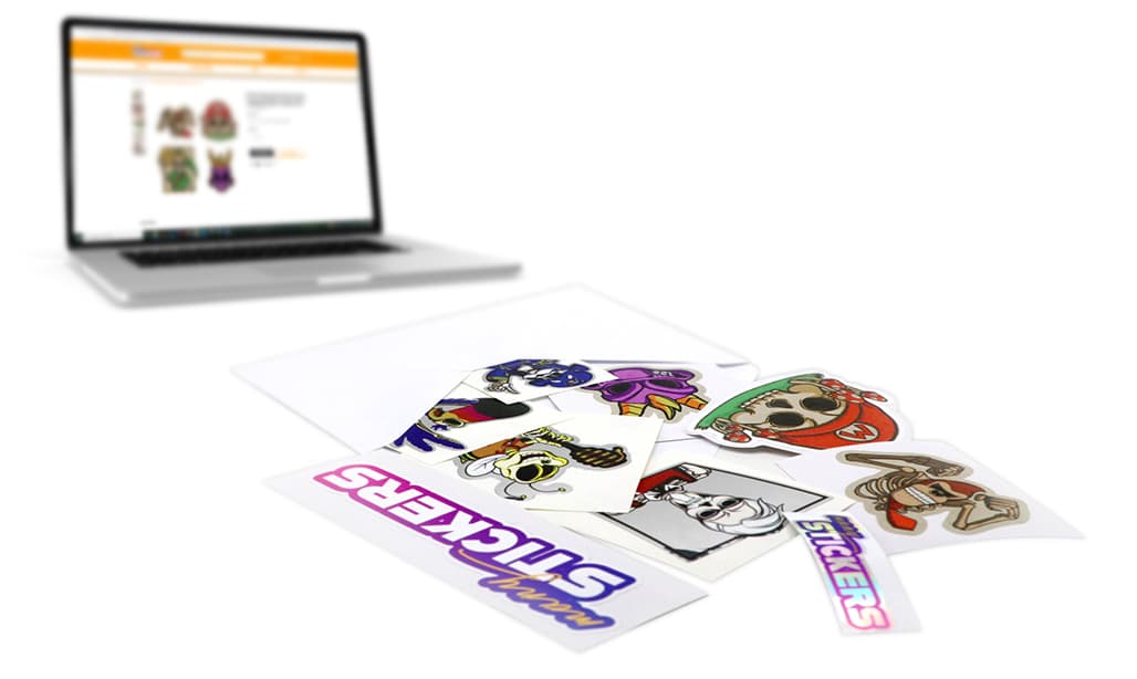 A laptop showing the Many Stickers customizer beside a spread of printed custom stickers